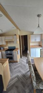 a kitchen with a table and chairs in a room at Pcj caravan hire in Kinmel Bay