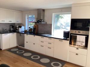a kitchen with white cabinets and a large window at 4 star holiday home in SÖLVESBORG in Falkvik +27 photos
