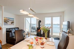 Una sala de estar con una mesa y una sala de estar con chimenea. en Schleivilla, en Olpenitz
