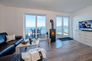 Una sala de estar con un sofá y una chimenea. en Schleivilla, en Olpenitz
