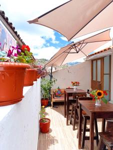 クスコにあるEcoterra Pampa del Castilloのテーブルと椅子と傘のあるパティオ
