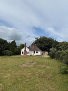 a white house with a grassy field in front of it at Pendene in Hinton