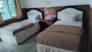two beds sitting next to each other in a room at Hotel Wailiti in Maumere +40 photos