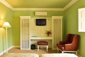 a bedroom with green walls and a chair and a tv at Pousada Convento de Evora in Évora