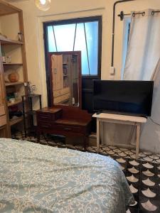 a bedroom with a bed and a desk and a television at Amplio primer nivel centro histórico el círculo in Guatemala