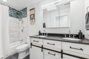 ein weißes Badezimmer mit zwei Waschbecken und einer Toilette in der Unterkunft Rare Modern Family Getaway ~ 3 Acres & Game Room in Elden Pueblo + 20 Fotos