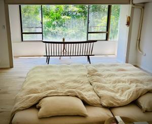 a large bed in a room with a large window at Oyado S in Hakone