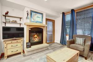 a living room with a fireplace and a television at Ski-In Ski-Out Zephyr 1 Bedroom Condo 2204 in Winter Park