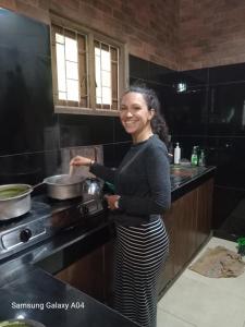 a woman standing in a kitchen preparing food at The Bridge Viwe Cabin in Norton Bridge