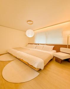 a bedroom with a large bed and a chair at 연남동,경의선숲길,홍대입구2번출구,올리브영,연세대,세브란스병원,2룸3베드,Ak홍대쇼핑,짐보관 in Seoul