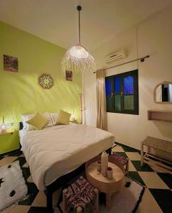 a bedroom with a large bed and a chandelier at Riad Dar Sahara - Panoramic Rooftop & Outdoor Shower in Nkob +70 photos