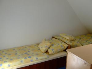 two beds in a small room with yellow sheets at Relax Apartmans in Balatonszemes