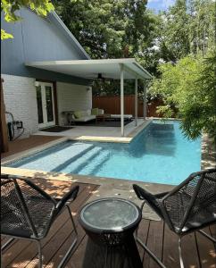 a swimming pool with two chairs and a table at Stylish 3BR Home + Private Pool in Austin
