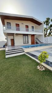 a large building with a lawn in front of it at Prime pearl villa in Thūr