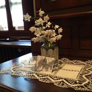 un jarrón lleno de flores blancas en una mesa en La Casona de Benito, en Cudillero