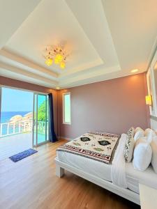 a bedroom with a bed with a view of the ocean at Kohtao Hillside resort in Koh Tao