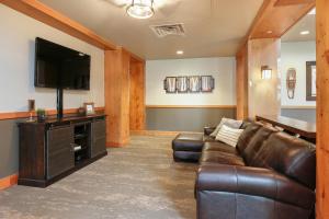 a living room with a leather couch and a flat screen tv at Expedition Station 8633 by Summit County Mountain Retreats in Snake River Health Services Incorporated Heliport