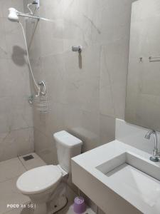 a bathroom with a toilet and a shower and a sink at Flat novo - Central - Vila Exposição - Garantia de conforto e satisfação in Montes Claros