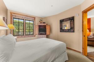 a bedroom with a white bed and a window at Dakota Lodge 8512 by Summit County Mountain Retreats in Snake River Health Services Incorporated Heliport +38 photos