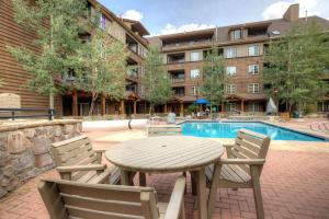 a wooden table and chairs next to a swimming pool at Dakota Lodge 8512 by Summit County Mountain Retreats in Snake River Health Services Incorporated Heliport