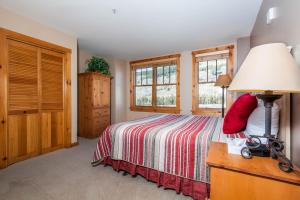a bedroom with a bed and a lamp and windows at Buffalo Lodge 8391 by Summit County Mountain Retreats in Snake River Health Services Incorporated Heliport +22 photos