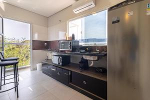 a kitchen with a counter with a sink and a microwave at ApTropea: Conforto, Natureza e o Som do Mar in Praia Guaratuba