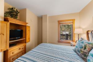 a bedroom with a bed and a flat screen tv at Expedition Station 8576 by Summit County Mountain Retreats in Snake River Health Services Incorporated Heliport +23 photos