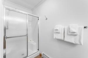 a bathroom with a shower and white towels at Saddle Ridge Townhomes 253 by Summit County Mountain Retreats in Sentinel Island +38 photos