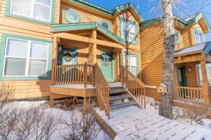 a wooden house with a wooden porch in the snow at Saddle Ridge Townhomes 253 by Summit County Mountain Retreats in Sentinel Island