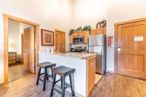 eine Küche mit einer Theke, einem Kühlschrank und Stühlen in der Unterkunft Arap Ldg 8134 in Snake River Health Services Incorporated Heliport