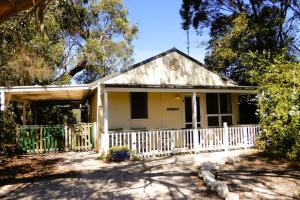 a small white house with a white fence at The Shanty in American River