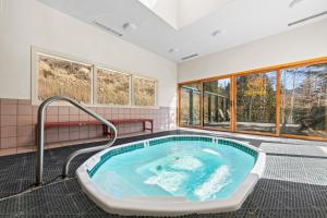 a hot tub in a room with windows at Saints John 2539 by Summit County Mountain Retreats in Snake River Health Services Incorporated Heliport