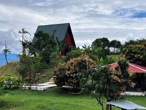 a house with a red barn and some bushes and trees at Cabaña Finca La Manuela1 in Garzón