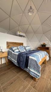 YaguaráEscapada en Domo con Paisajes Increíbles的卧室里有一张铺着蓝白床单的床