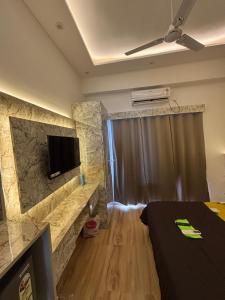 ein Zimmer mit einem Bett und einem Fernseher an der Wand in der Unterkunft Kanha stay in Greater Noida