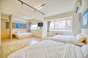 a large bedroom with two beds and a couch at 看海季節&聽海約定精緻旅店 in Magong