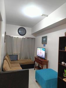 大雅台Jewels Staycation at Cityland Tagaytay Prime Residences的客厅里有一张沙发和一台电视