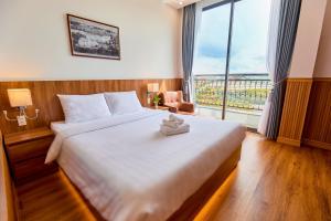 a bedroom with a large bed with a large window at Lotus Hotel Đà Lạt in Da Lat