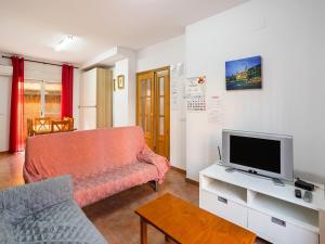 a living room with a couch and a tv at Leisurely Apartment in Lepe with Swimming Pool in La Antilla