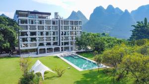 ein Hotel mit Pool und Bergen im Hintergrund in der Unterkunft Xingyun Mujing Hotel in Yangshuo