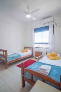 a bedroom with two beds and a window at Ubicación perfecta con vista al Puente, AC, WIFI in Vuelta del Paraguayo