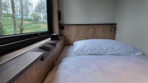 a bedroom with a bed and a large window at Jambuluwuk Bromo Poshtel in Pasuruan +30 photos