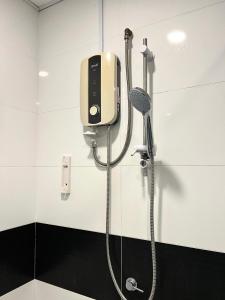 a shower with a phone on the wall in a bathroom at Mansion One by Sky Hive in George Town