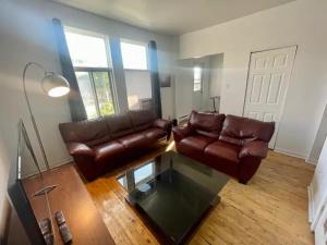 a living room with a leather couch and a glass table at FULL KITCHEN 12MIN DTOWN Room B in Montréal