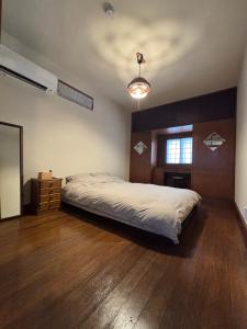 a bedroom with a large bed and a wooden floor at 梅の宿 Umenoya 小田原城5分箱根15分城下町と温泉を愉しむ東海道の古民家ステイ PC1 in Odawara