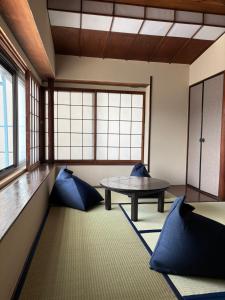 a room with a table and blue pillows at 梅の宿 Umenoya 小田原城5分箱根15分城下町と温泉を愉しむ東海道の古民家ステイ PC1 in Odawara