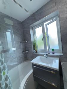 a bathroom with a sink and a shower and a tub at Stylish Stay Near Everything in Dagenham +12 photos