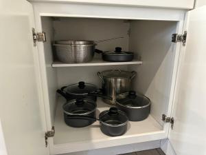 a shelf with pots and pans in a kitchen at Bright & Airy 1 BDRM Private Apt in Albany +6 photos