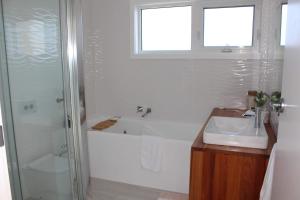 a bathroom with a tub and a sink and a shower at Sunset on Tamar in Legana