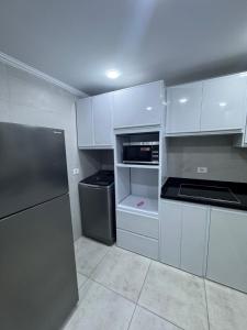 a kitchen with white cabinets and a refrigerator at The Royal Sea View Suite in Port Said